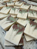 Marbled soap bars in white, green, and brown on a rustic wooden surface